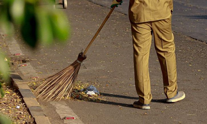 a man with a broom on a street